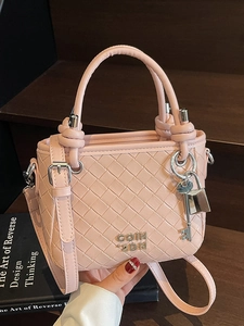 Pale pink woven leather bucket bag with top handles and detachable shoulder strap