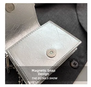 Close-up of metallic silver mini bag showing magnetic snap closure and crinkled texture