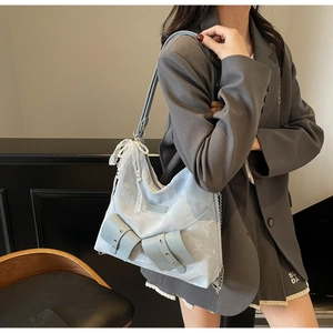 Detail of light blue tote bag featuring delicate white lace trim and elegant pearl charms