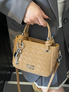 Chic khaki woven bucket bag with silver key charm and long shoulder strap