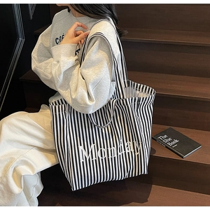 Detail of oversized black and white striped canvas tote bag with Monday text print