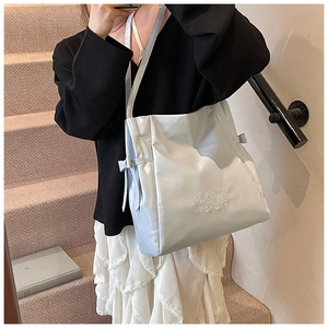 Detailed view of soft leather tote bag with silver metallic finish and bow decoration
