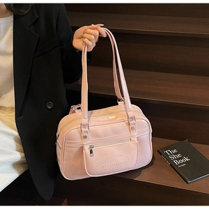 Close-up of pink glossy faux leather shoulder bag with embossed logo on front pocket