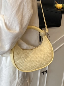Minimalist light yellow woven hobo bag for women with round handle and shoulder strap