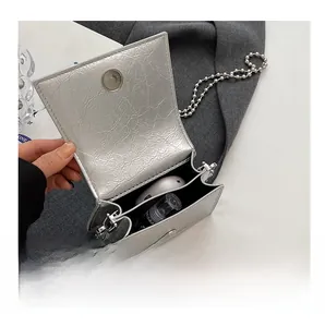Detail view showing interior capacity of a silver wrinkled mini bag with bead chain strap