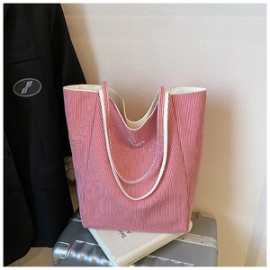 Detail view of a red and white striped canvas tote bag on a silver suitcase for commuting