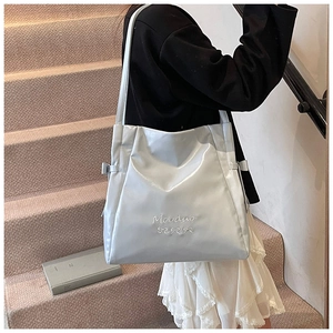 Close-up of shiny blue tote bag featuring ribbon details and Mooduo lettering