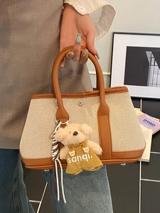 Minimalist canvas bucket bag with brown leather trim and cute teddy bear charm