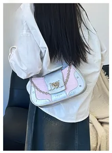 Close-up of pink and blue contrast crossbody bag with crocodile texture and heart lock