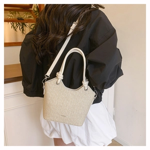 Détail du sac seau tissé avec poignée en cuir et bandoulière amovible en intérieur