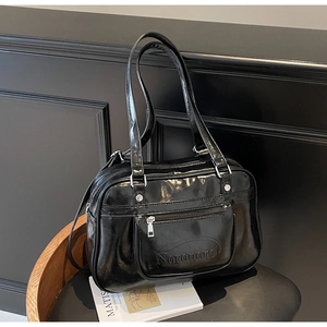 Detail of glossy black oil-wax leather shoulder bag featuring embossed Noronoro logo