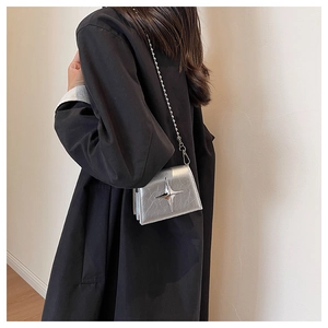 Silver wrinkled leather mini bag with star charm and metallic chain shown on model