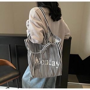 Detail of large canvas tote bag with black and white stripes and Monday text print