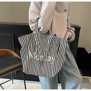Detailed side view of large canvas tote bag with black and white vertical stripes