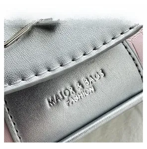 Close-up of stone texture leather surface and embossed brand logo on the handbag