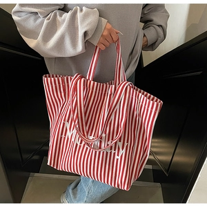 Detail of red and white striped canvas tote bag featuring large Monday text print