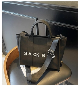 Detail of black canvas tote bag with SACK BAG print and adjustable nylon shoulder strap