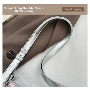 Detail of adjustable silver metallic strap with polished metal hook on trendy bag