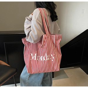 Detail of red and white striped canvas tote bag with Monday text print on model