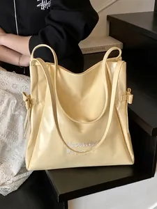 Creamy yellow large tote bag with Mooduo embroidery and side bow on black steps