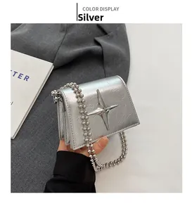 Close-up of silver crossbody mini bag with star metal ornament and beaded chain strap