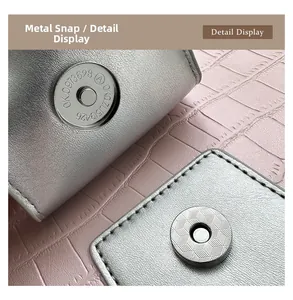 Macro detail of silver magnetic snap button and pink crocodile pattern leather bag