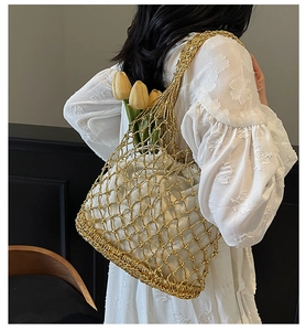 Detail of gold woven mesh shoulder bag with white inner lining and floral decoration