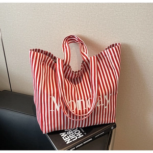Detail of red and white striped canvas tote bag with Monday text print on art books
