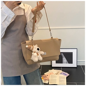 Detail of khaki pebbled leather shoulder bag with silver twist lock and puppy charm