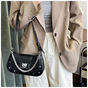 Detail of black faux crocodile leather shoulder bag with silver chain and heart buckle