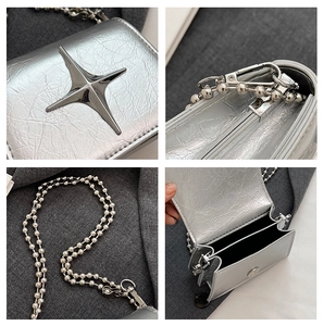 Detail of silver metallic mini bag with star charm, bead chain and magnetic closure
