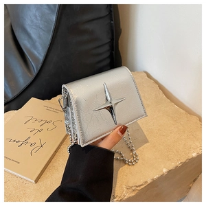 Detail of silver cracked leather mini bag with metal star and ball chain strap