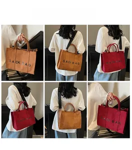 Detail view of large canvas tote bag in brown and red with adjustable shoulder straps