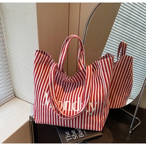 Detail of red and white striped canvas tote bag with Monday text print and wide straps