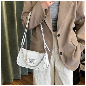 Detail of white crocodile embossed underarm bag with silver heart buckle and chain