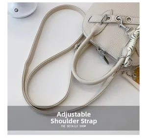 Detail of off-white lychee leather handbag showing silver hardware and adjustable strap