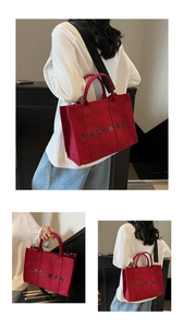 Detail of red canvas tote bag with black SACK BAG print and detachable shoulder strap