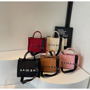 Five assorted canvas tote bags in red, beige, black, brown and pink with wide straps