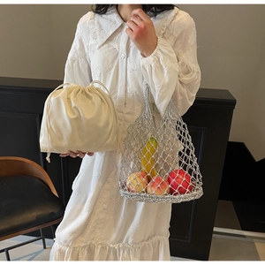 Detailed view of silver hollow woven mesh bag with beige drawstring inner pouch insert