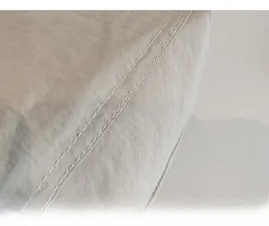 Detailed close-up showing fine double-row stitching on high-quality off-white canvas tote bag