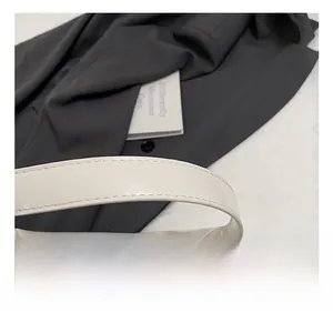 Gros plan du sac en cuir souple crème avec chaîne en perles et détail de poignée