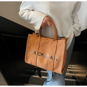 Detail view of khaki canvas tote with SACK BAG print and adjustable wide strap