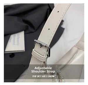 Détail de la bandoulière réglable avec boucle en métal argenté sur sac en cuir crème