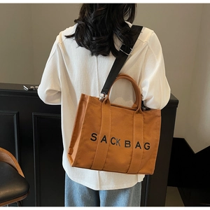 Detail of caramel canvas tote bag with SACK BAG print and adjustable black shoulder strap