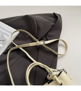 Détail du sac seau en cuir beige crème avec poignée nouée et bandoulière réglable