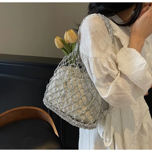 Detail of silver woven mesh tote bag with white drawstring liner and yellow tulips