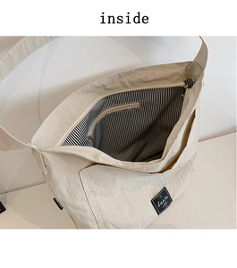 Interior detail of large tote bag with striped lining and internal zipper pocket