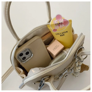 Top view of cream shell bag interior showing storage space for phone and makeup