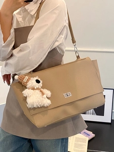 Minimalist khaki underarm business bag with flap closure and silver lock in leather finish