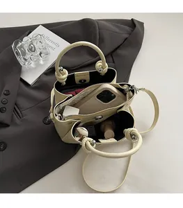 Vue macro du sac seau plissé beige avec un compartiment intérieur spacieux à trois couches